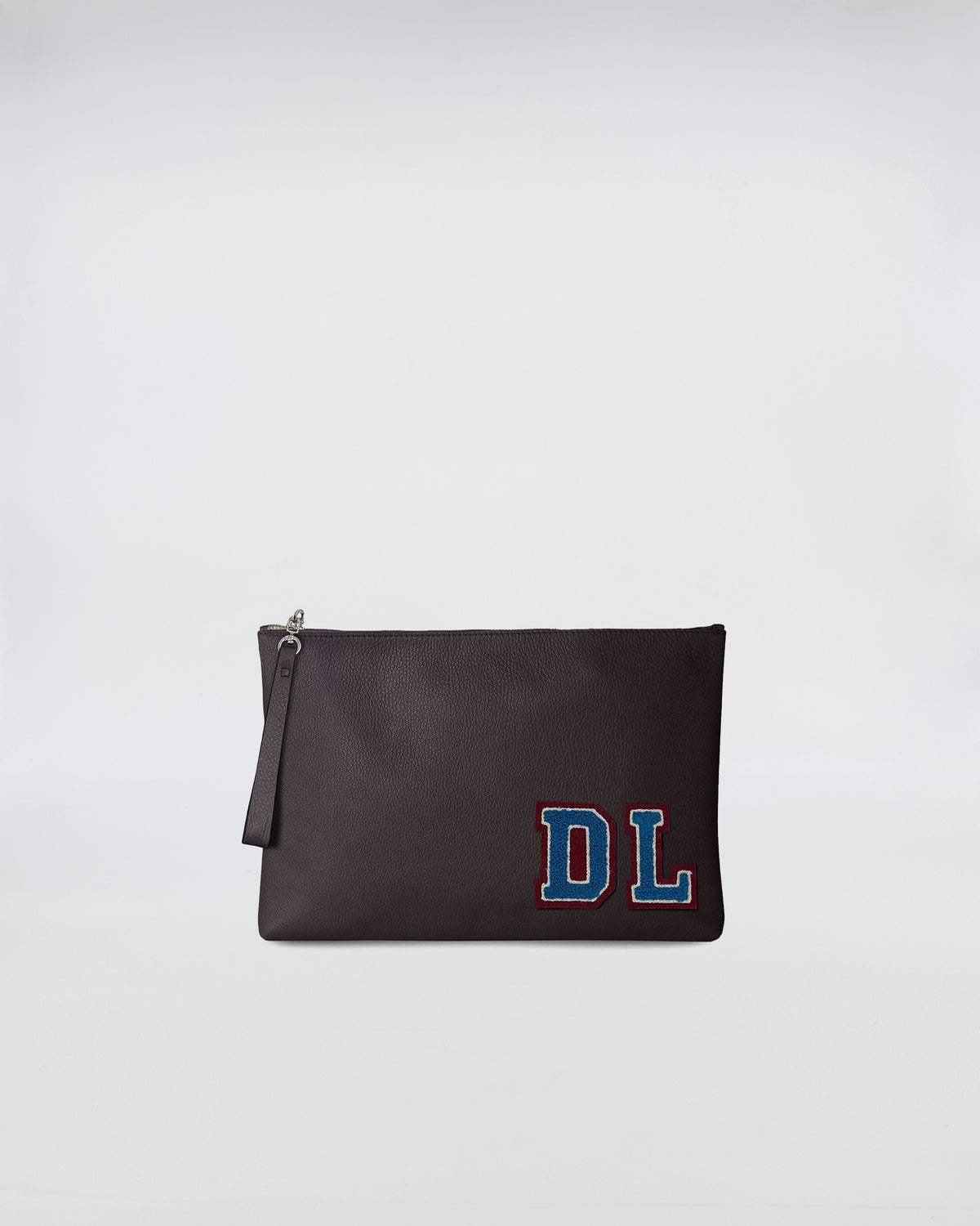 BUSTA A4 PERSONALIZZATA in pelle scura con patch DL, chiusura con zip e manicotto per portarla a mano.