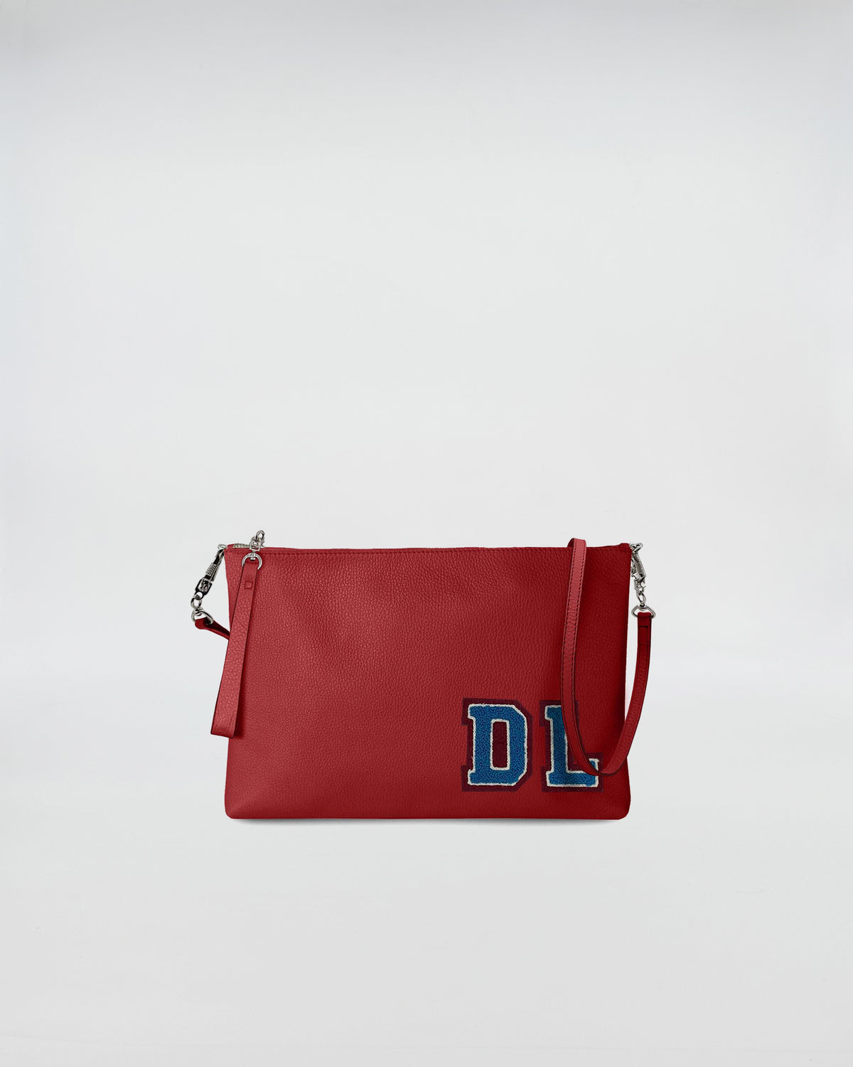 BUSTA A4 PERSONALIZZATA CON TRL in red leather with removable strap and blue patch detail.