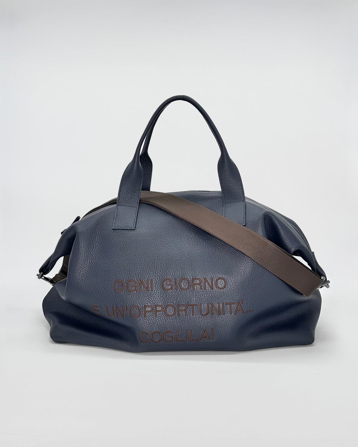 Navy travel bag with handles and adjustable strap, featuring motivational text on the side.