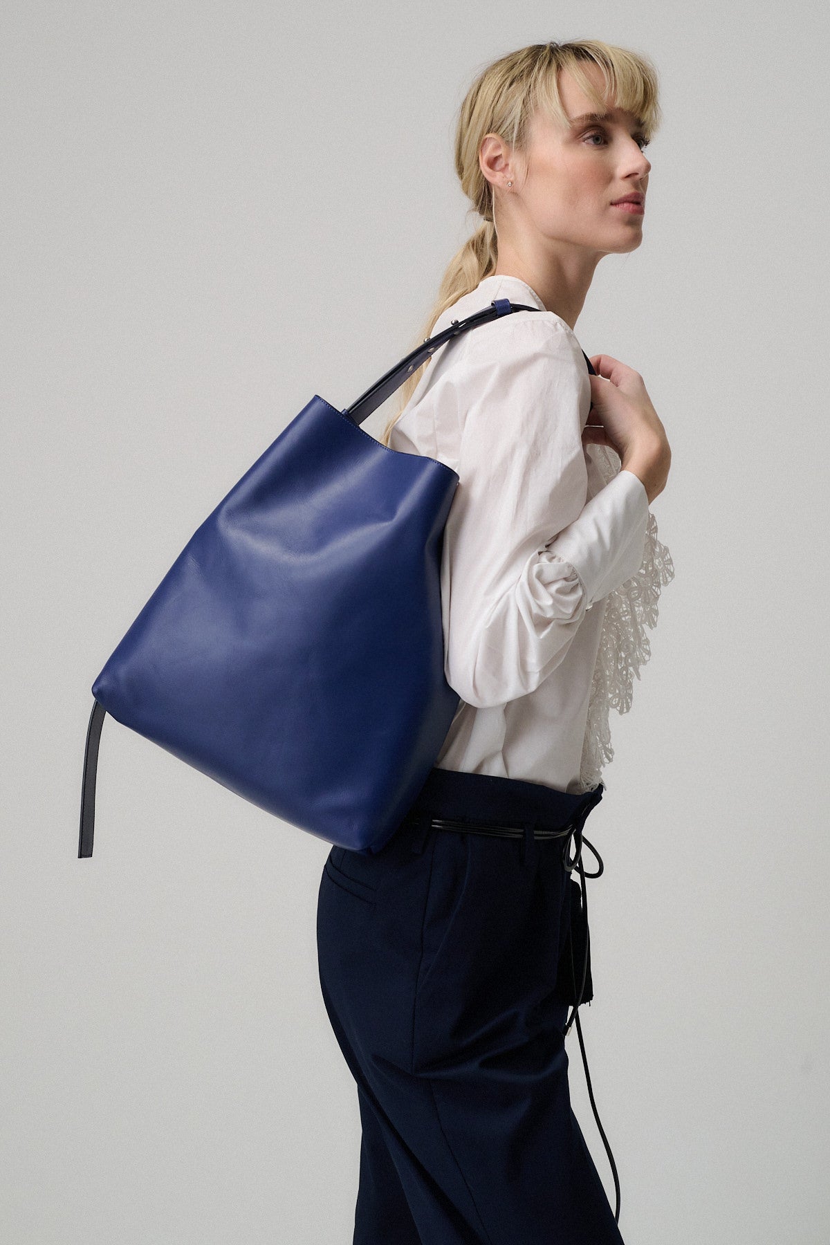 Modella che indossa la borsa SOPHIA VITELLO LISCIO in pelle blu, perfetta per un utilizzo quotidiano.
