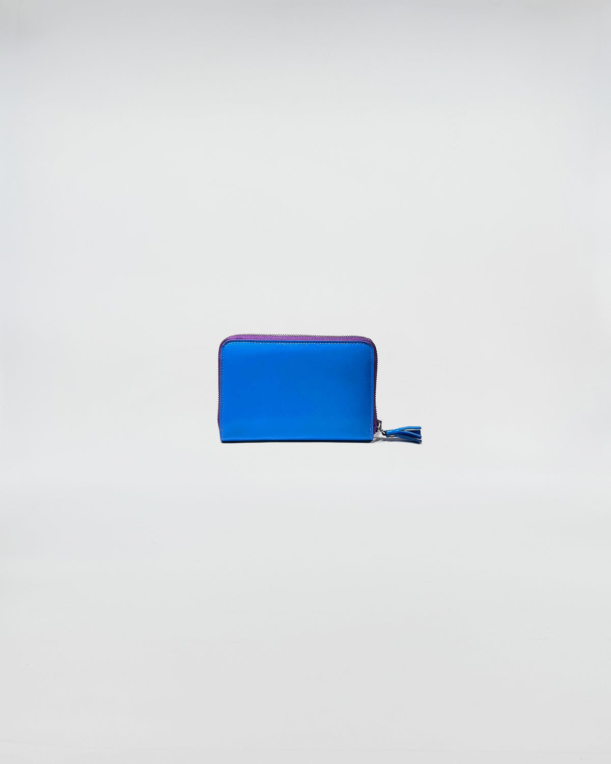 Portafoglio Zip Small in blu con chiusura zip e dettagli in viola, accessorio elegante per uso quotidiano.