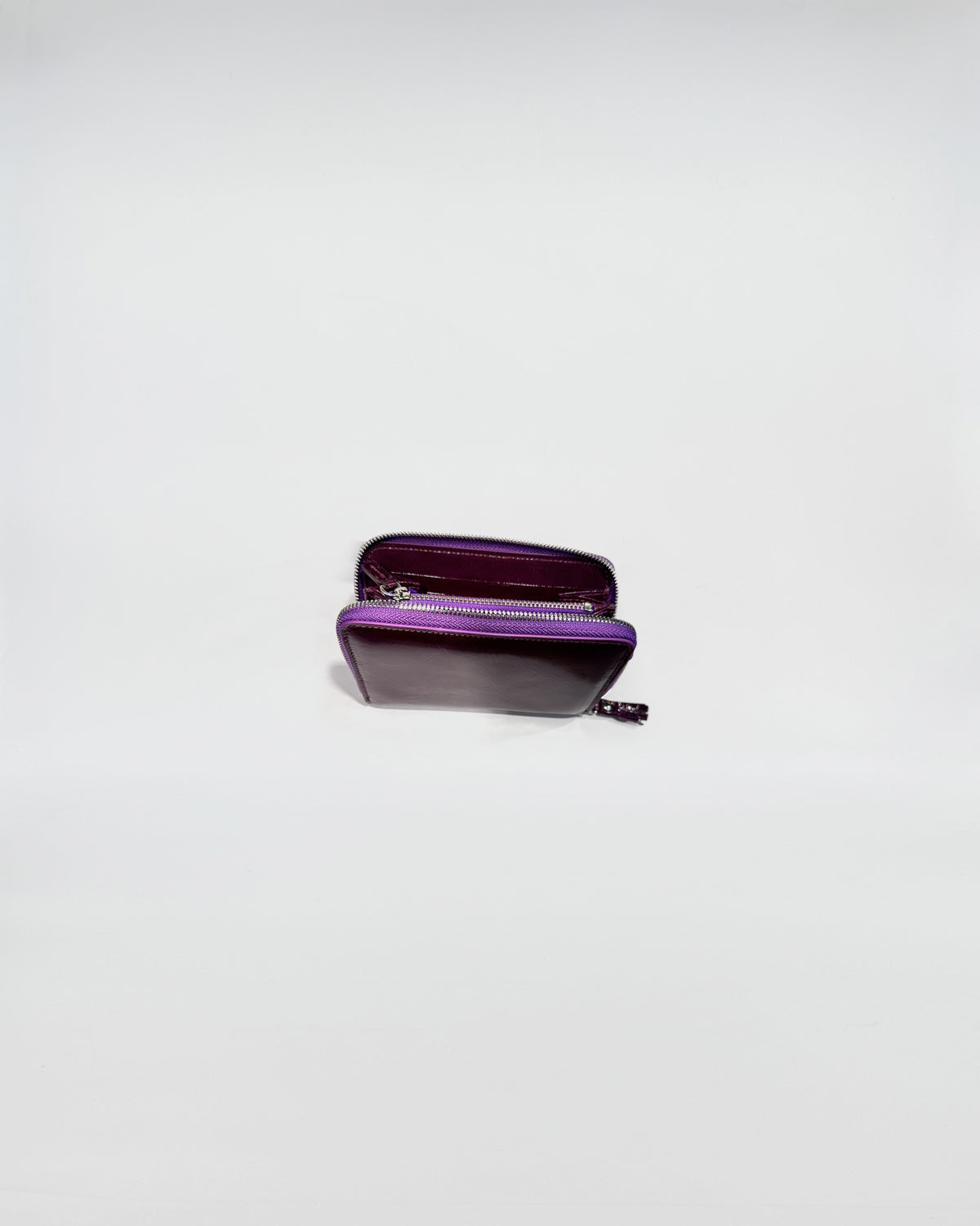 Portafoglio Zip Small in vitello con chiusura zip viola e interni viola, elegante e pratico per uso quotidiano.