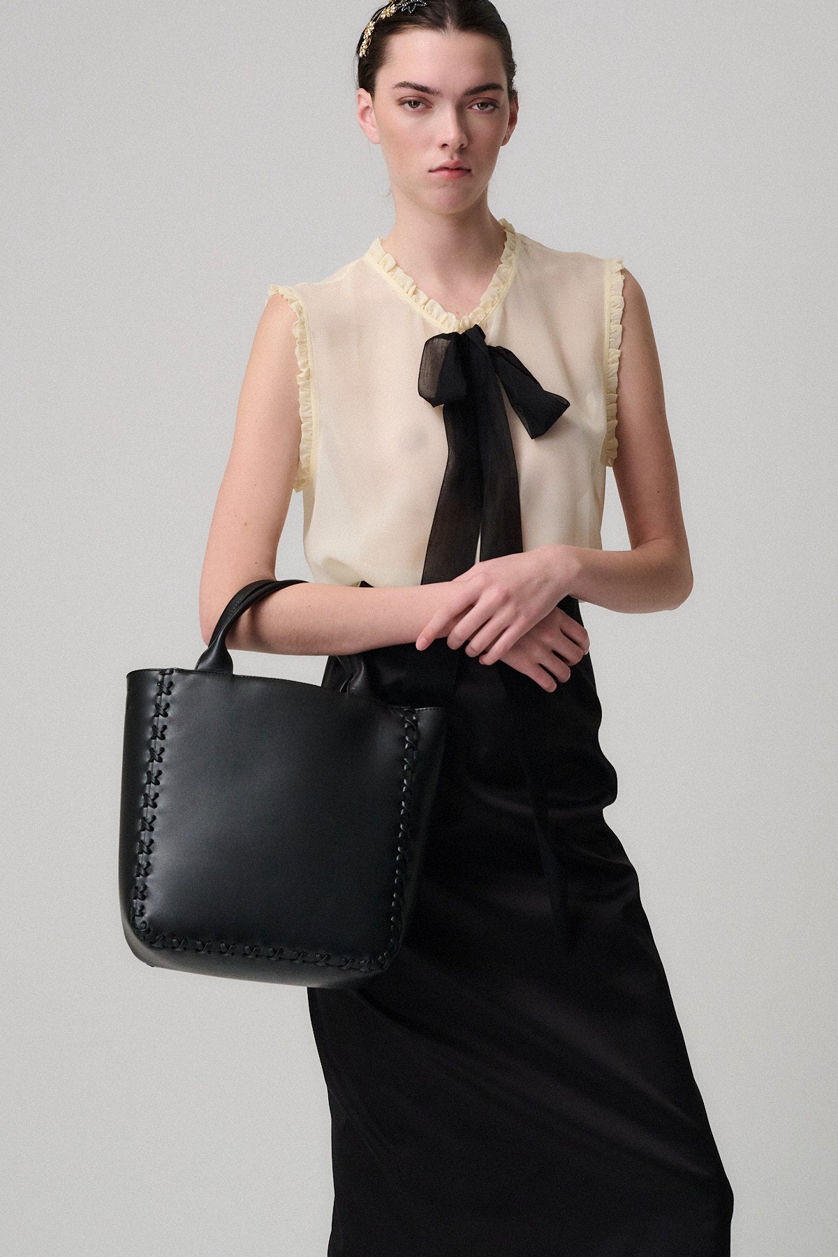 Donna in abito elegante con borsa in pelle nera, modello BEAUTY IN PELLE SIMONE.