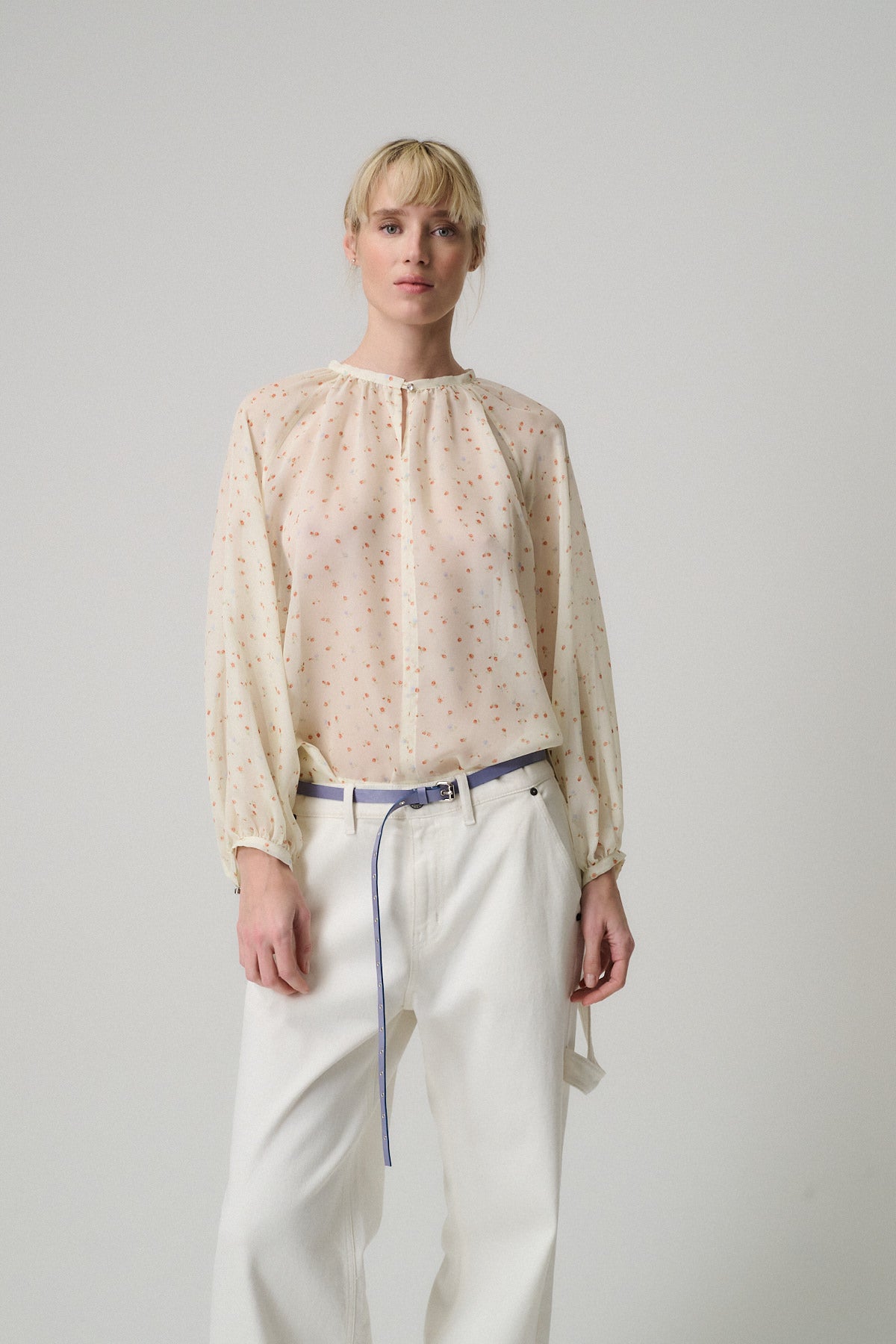 CAMICIA COLETTE  FANTASIE ROSE indossata da una donna con capelli biondi, abbinata a pantaloni bianchi.