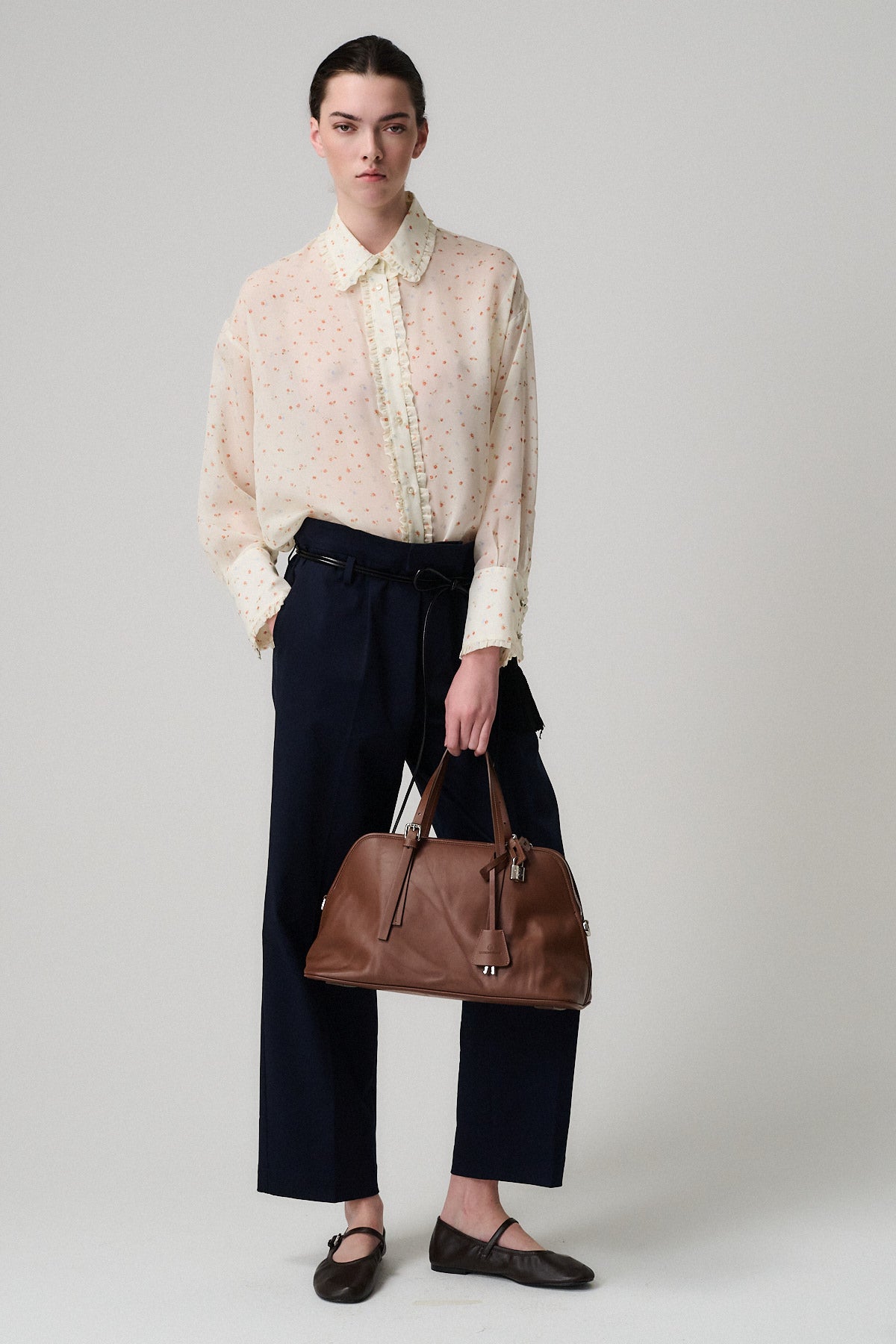 CAMICIA ISOTTA SETA CON ROUGE indossata con pantaloni blu e borsa marrone, look sofisticato e contemporaneo.