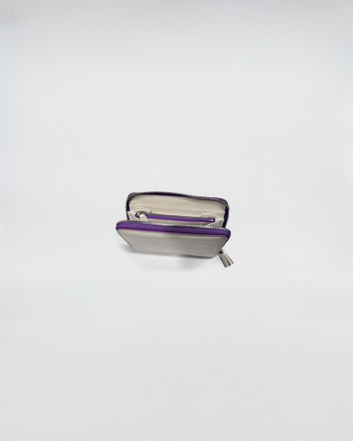 Portafoglio Zip Small con chiusura a zip viola, interni in pelle e scomparti per carte e contanti.